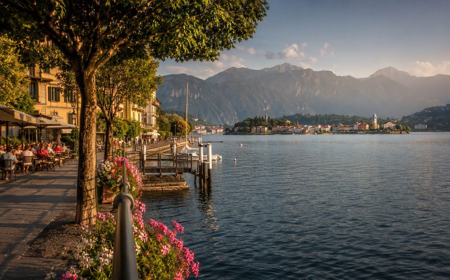Promenade du front de lac de Menaggio avec fleurs et bateaux amarrés sur le lac de Côme